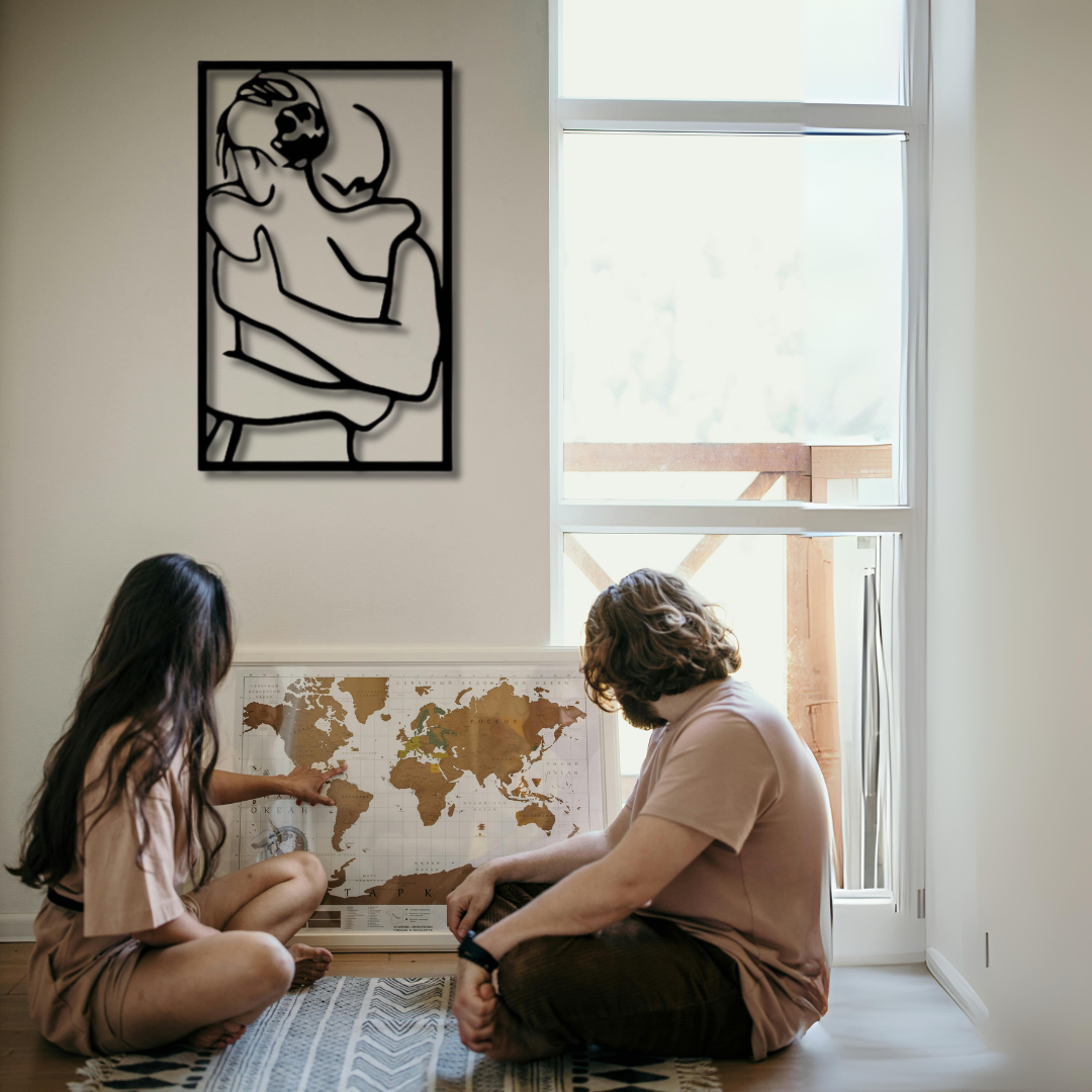 لوحة فنية معدنية على الحائط تصور زوجين يحتضنان بعضهما